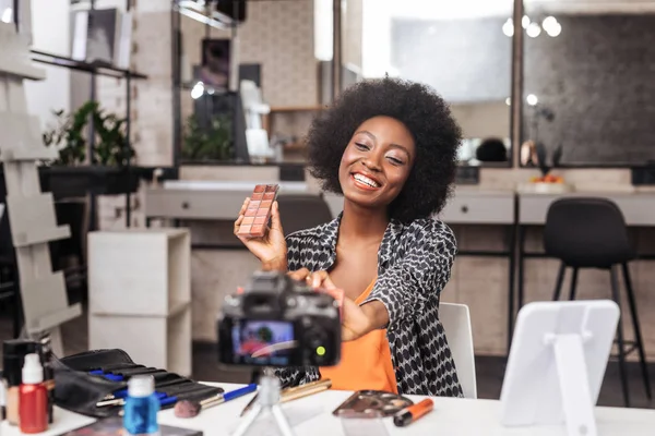 Hermosa mujer de piel oscura con el pelo rizado sonriendo brillantemente — Foto de Stock