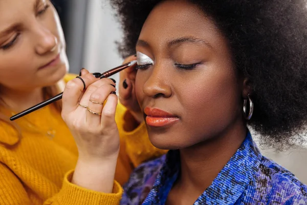 Pretty young stylist in a yellow thick sweater feeling inspired — Stock Photo, Image