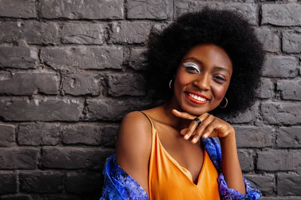 Pretty african american model in an orange top feeling happy