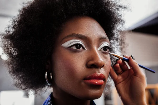 Dark-skinned african american model with bright eyeshadows looking thoughtful — Stock Photo, Image