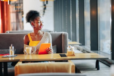 Açık omuz pencereden bakan ile kazak giyen kadın