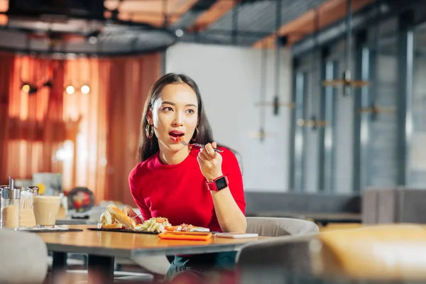 黑头发的女人穿着红色智能手表吃美味的午餐 — 图库照片