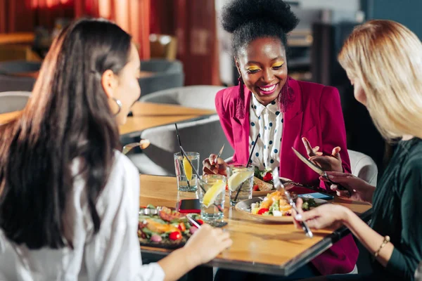 Três mulheres comendo saladas saudáveis e bebendo limonada — Fotografia de Stock