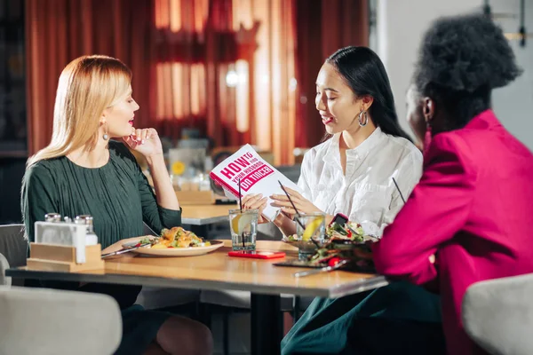 Three young single women reading book about finding husband — Stock Photo, Image