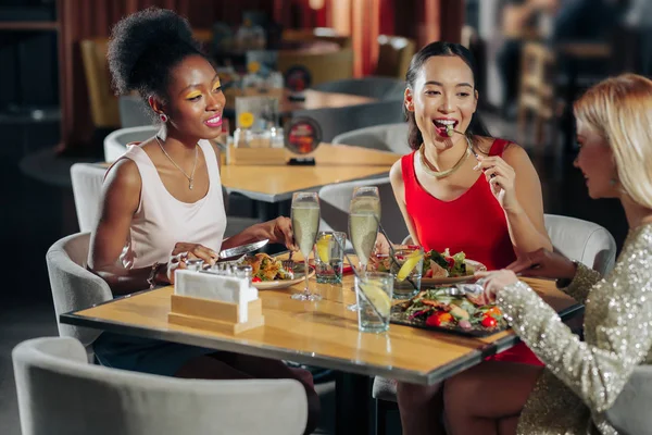 Compañía de tres mejores amigos sintiéndose descansados mientras están sentados en el restaurante —  Fotos de Stock