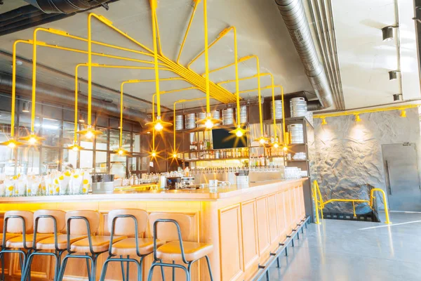 Soporte de bar grande moderno con bonitas lámparas de color amarillo brillante — Foto de Stock