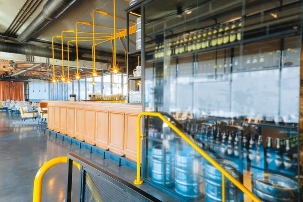 Botellas de cerveza situadas cerca de la pared de vidrio y soporte de bar — Foto de Stock