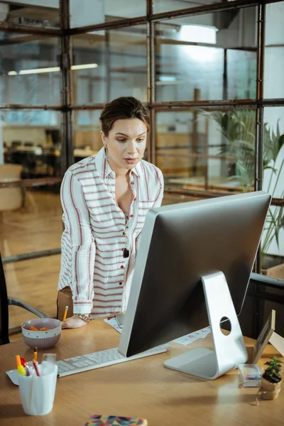 Välmående affärskvinna undersöker stor datorskärm — Stockfoto