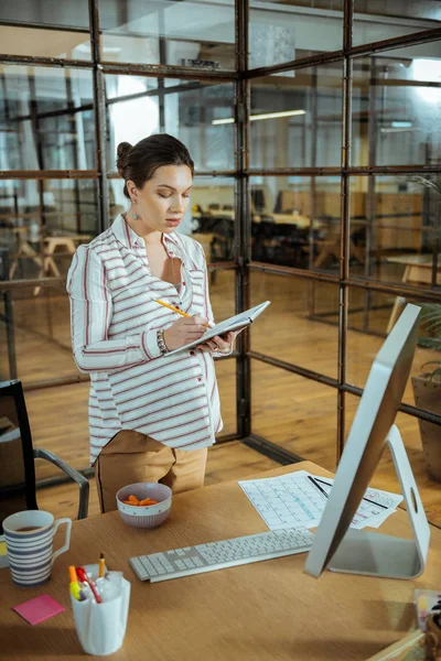 Embarazada mujer de negocios vistiendo pantalones beige y blusa de gran tamaño —  Fotos de Stock