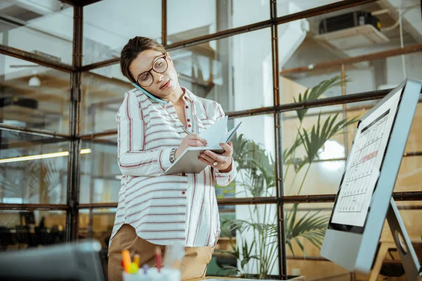 Busy businesswoman checking her schedule while arranging meeting