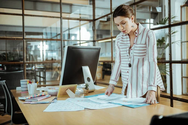 Table with documents. Busy pregnant successful businesswoman standing near table with documents