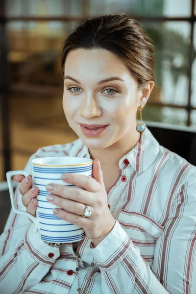 Close-up van de mooie donker-haired vrouw met grote kopje thee — Stockfoto