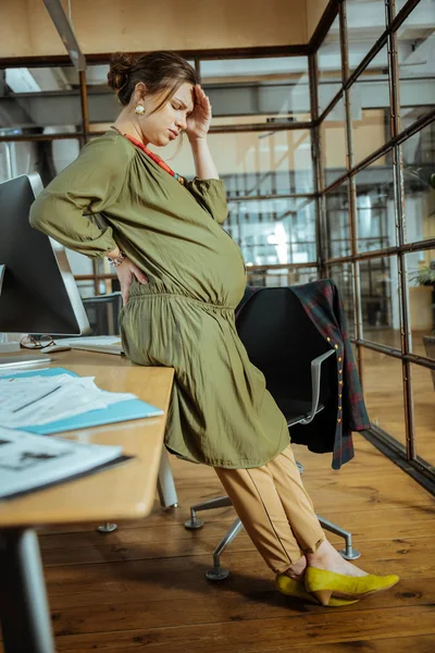 Mulher de negócios grávida usando sapatos amarelos sentindo-se horrível no trabalho — Fotografia de Stock