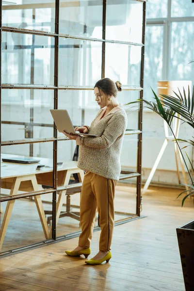 Eleganta affärskvinna holding hennes laptop medan du läser brev — Stockfoto