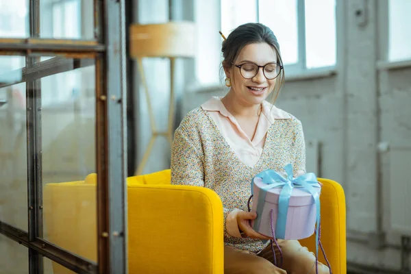 Alegre hermosa mujer sintiéndose satisfecha sosteniendo presente caja — Foto de Stock