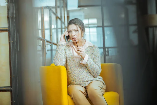 Mujer embarazada sosteniendo su teléfono inteligente azul mientras llama marido — Foto de Stock