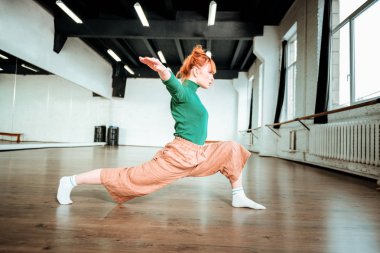 Güzel ince yoga dengeleme asana yaparken yeşil bir balıkçı yaka teknik direktör