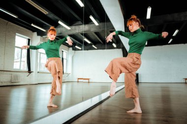 Ciddi seyir yeşil bir balıkçı yaka güzel kızıl saçlı profesyonel dansçı