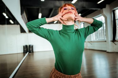 Kızıl saçlı Genç öğretmen dramatik görünümlü parlak makyaj ile dans.