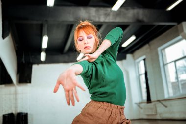 Kolunu uzanan yeşil bir balıkçı yaka Kızıl saçlı profesyonel koreograf