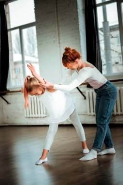 Kızıl saçlı öğrenci ile çalışan profesyonel modern dans öğretmeni