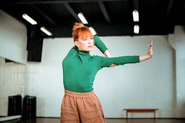 Mooie rode haired meisje in een groene coltrui staande in asana — Stockfoto