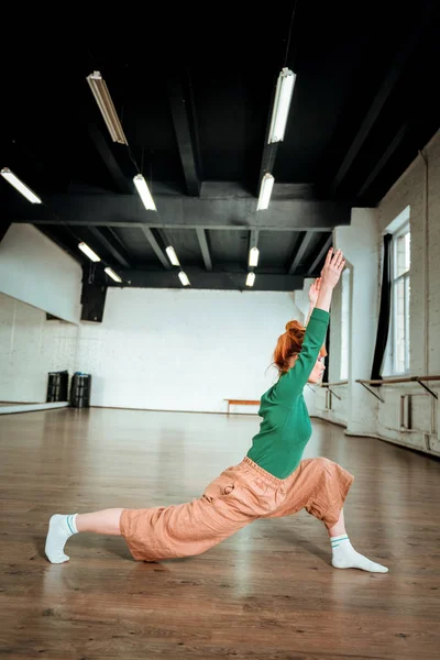 美丽的苗条瑜伽教练在一个绿色的高领毛衣做体式平衡 — 图库照片