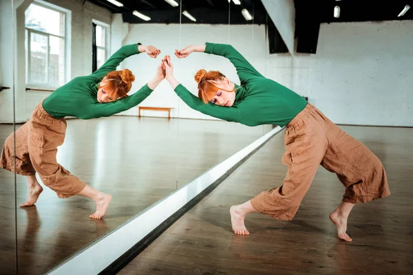 Professionelle moderne Tänzerin macht Bewegungen in der Nähe des Spiegels — Stockfoto