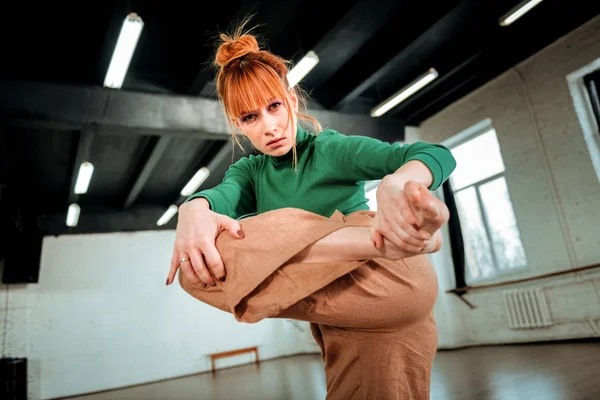 Red-haired professional choreographer with hair bun looking serious