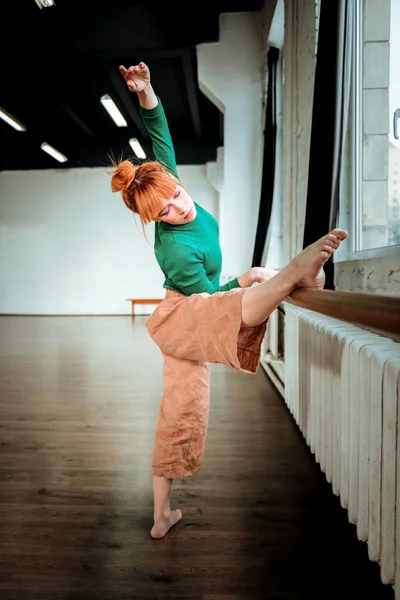 Jovem bailarina profissional de balé com coque de cabelo fazendo inclinação — Fotografia de Stock