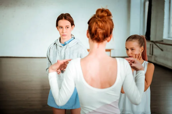 Профессиональная учительница современного танца с рыжими волосами разговаривает со своими учениками — стоковое фото