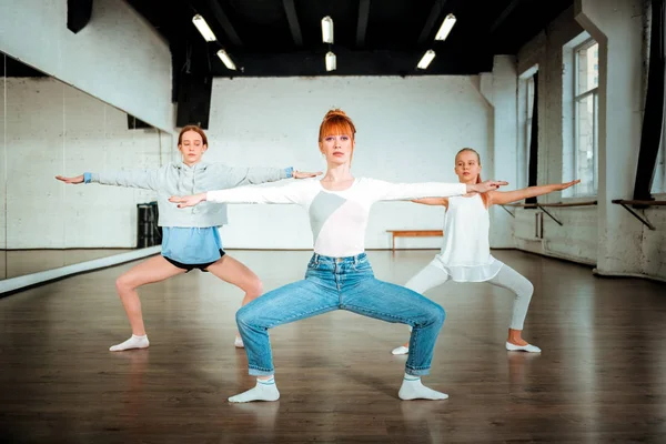 Smal vacker Balett lärare gör huk med två unga studenter — Stockfoto