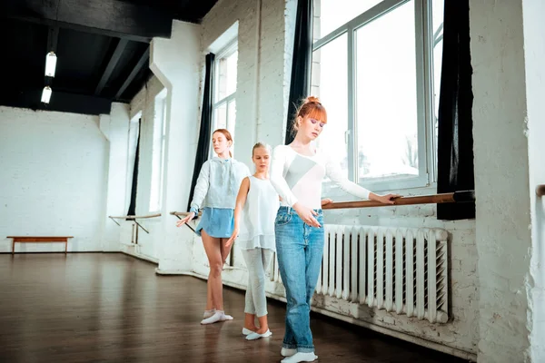 Red-haired ballet teacher and her students practicing the third ballet position — Stock Photo, Image