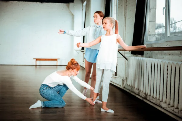 Rödhåriga Balett lärare i blå jeans korrigering fötter position — Stockfoto