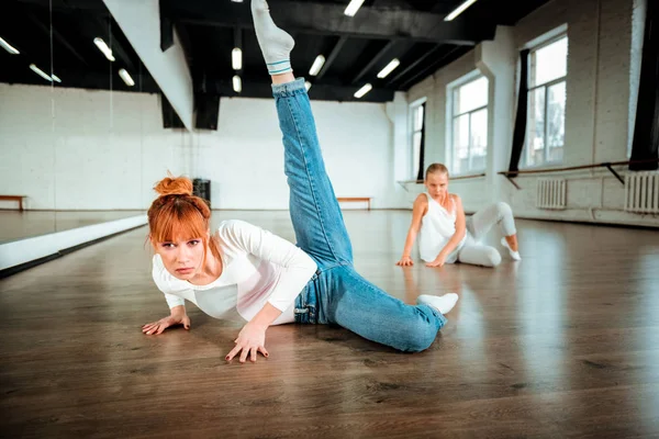 Profesora de ballet profesional en jeans azules haciendo swing de piernas —  Fotos de Stock