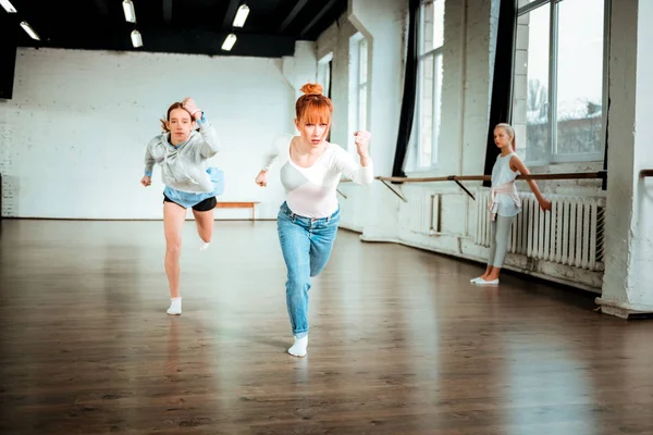 Profesora de ballet profesional en jeans azules y su estudiante haciendo columpios de brazos —  Fotos de Stock