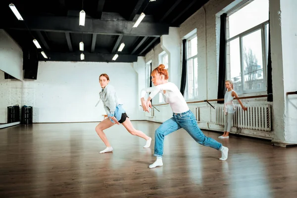 Professionele ballet leraar in spijkerbroek en haar student prachtig verplaatsen — Stockfoto