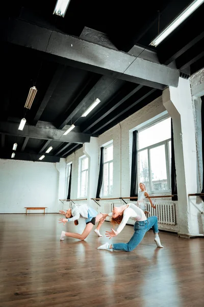 Professionele ballet leraar in spijkerbroek en haar student doet overkoepelende — Stockfoto
