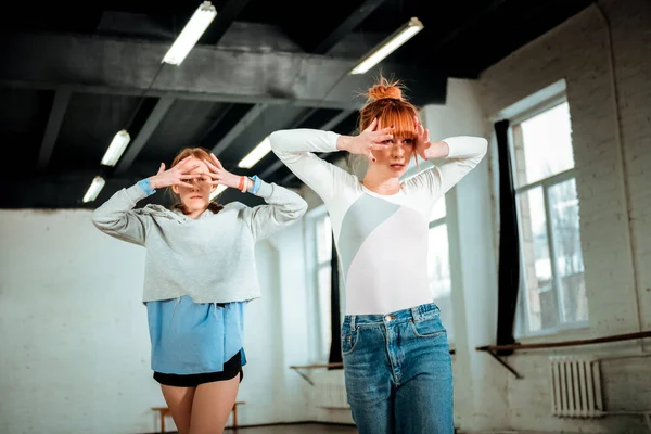 Schöne rothaarige Lehrerin in blauen Jeans und ein Student in schwarzen Shorts, die künstlerisch wirken — Stockfoto