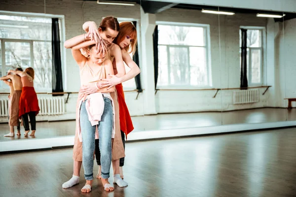 Joven profesora de danza pelirroja y sus estudiantes trabajando juntos —  Fotos de Stock