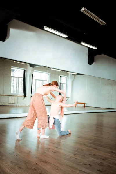 Twee studenten van een dansschool en hun leerkracht werken op een mooie beweging — Stockfoto