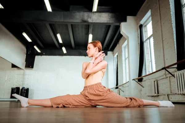 Leuk roodharige tiener in oranje broek doen been-split — Stockfoto