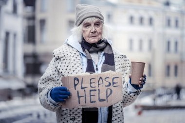 Sad aged woman asking people for help clipart