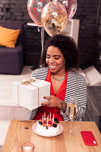 Joyful positive woman holding a gift box — Stock Photo, Image