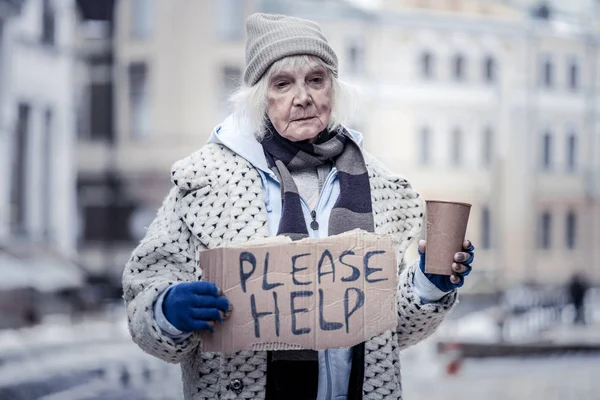 Sad aged woman asking people for help — Stock Photo, Image