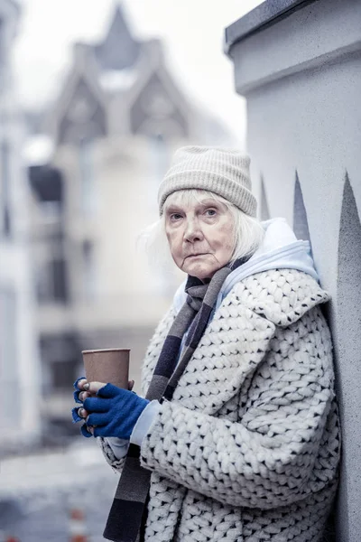 Mulher idosa deprimida pedindo-lhe dinheiro — Fotografia de Stock