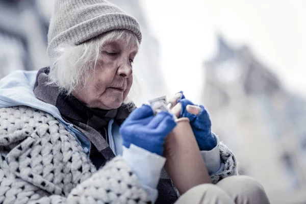 Nice aged woman taking money out of cup — Stock Photo, Image