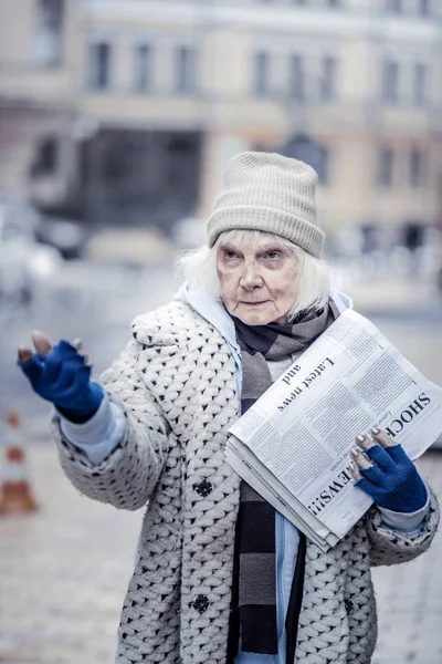 Femme malheureuse sans pom girl tenant un paquet de journaux — Photo