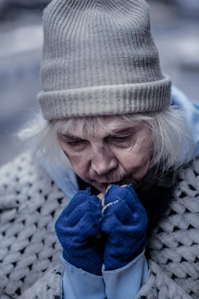 沮丧的无家可归的女人试图温暖她的手 — 图库照片