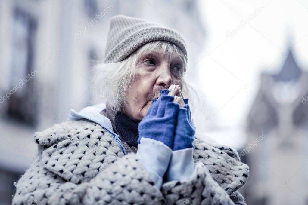 Unhappy poor aged woman feeling very cold